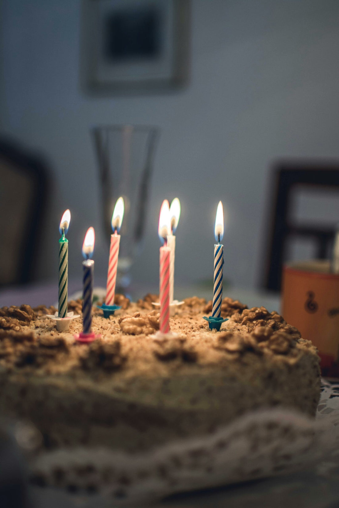 Close-up of a delicious birthday cake with colorful lit candles in a cozy setting.